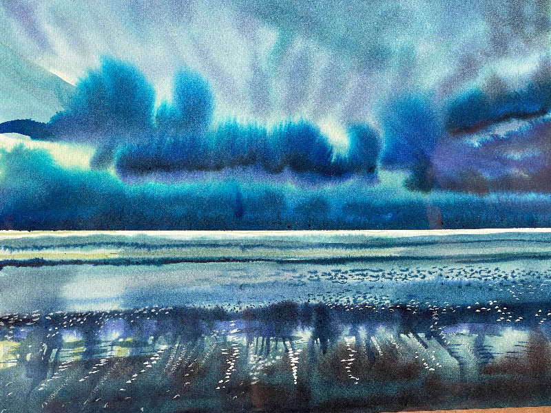 A watercolor painting depicting a stormy sea with dark clouds above and light reflecting off the wet sand.