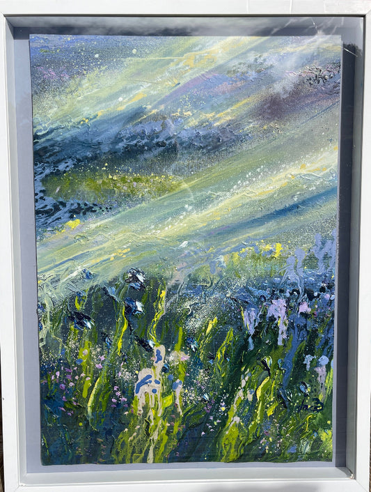 Framed artwork of a landscape with mountains and flowers